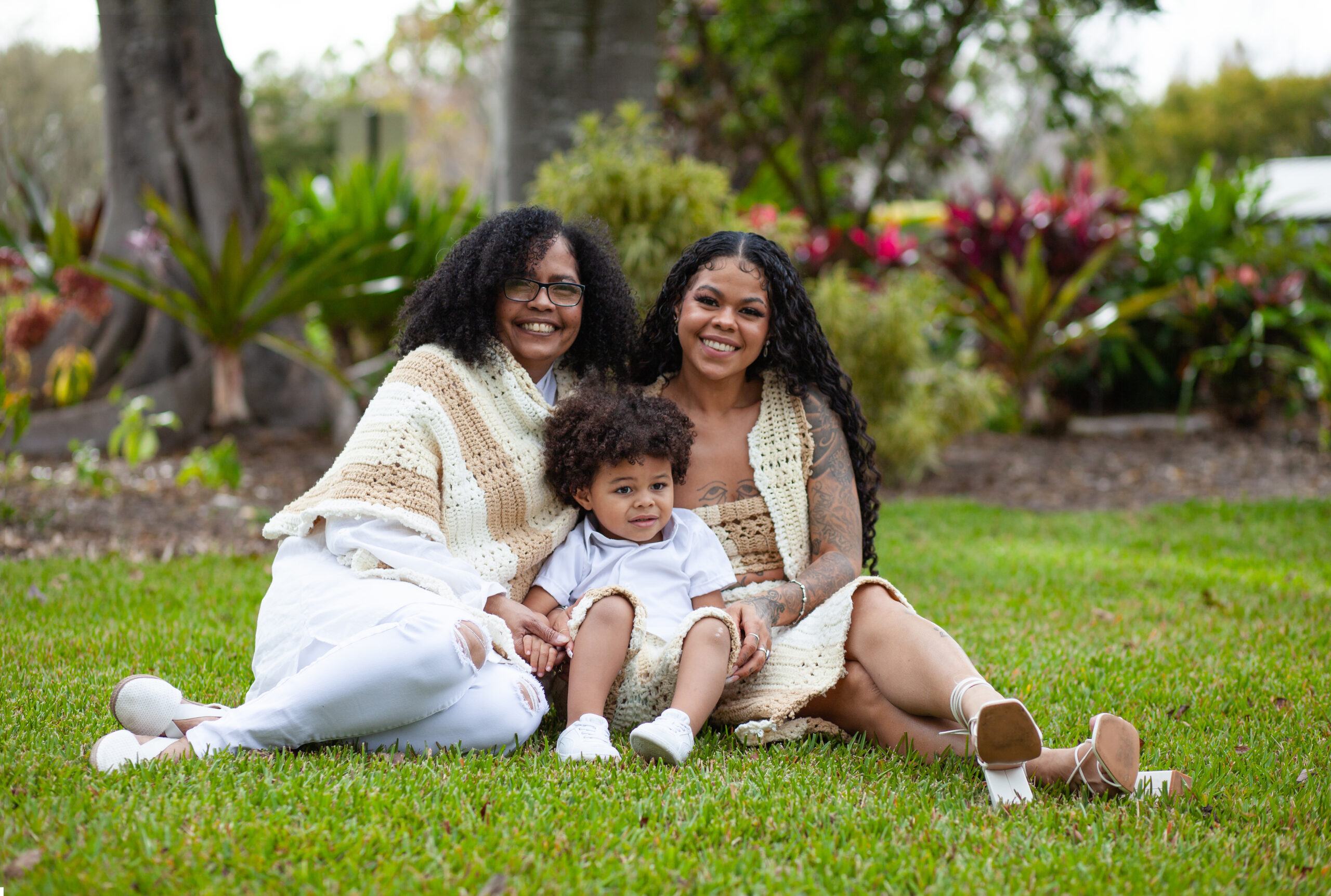 Smiling family photo, they are sitting in the grass