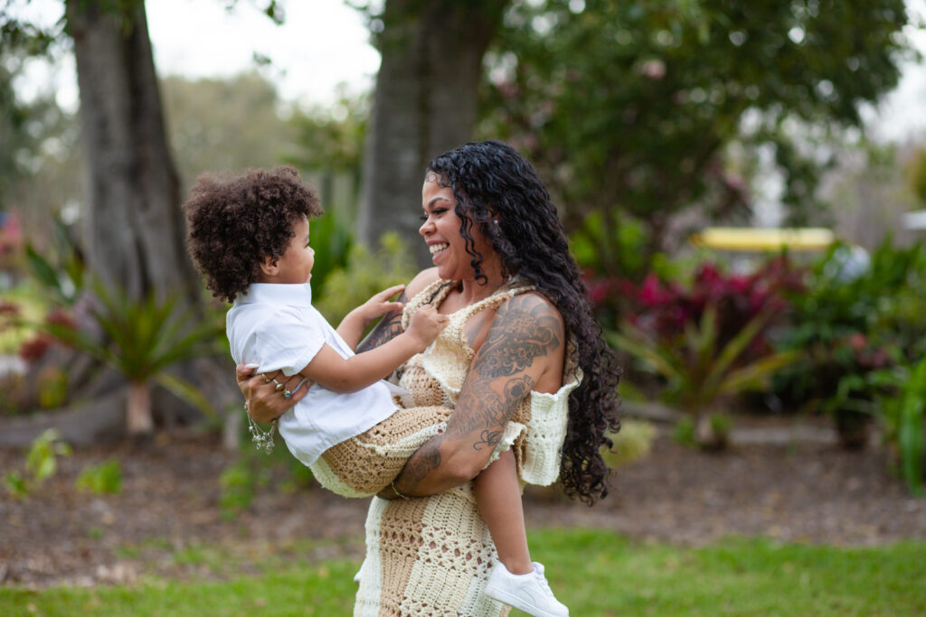 Mom smiles and spins around playing with her son