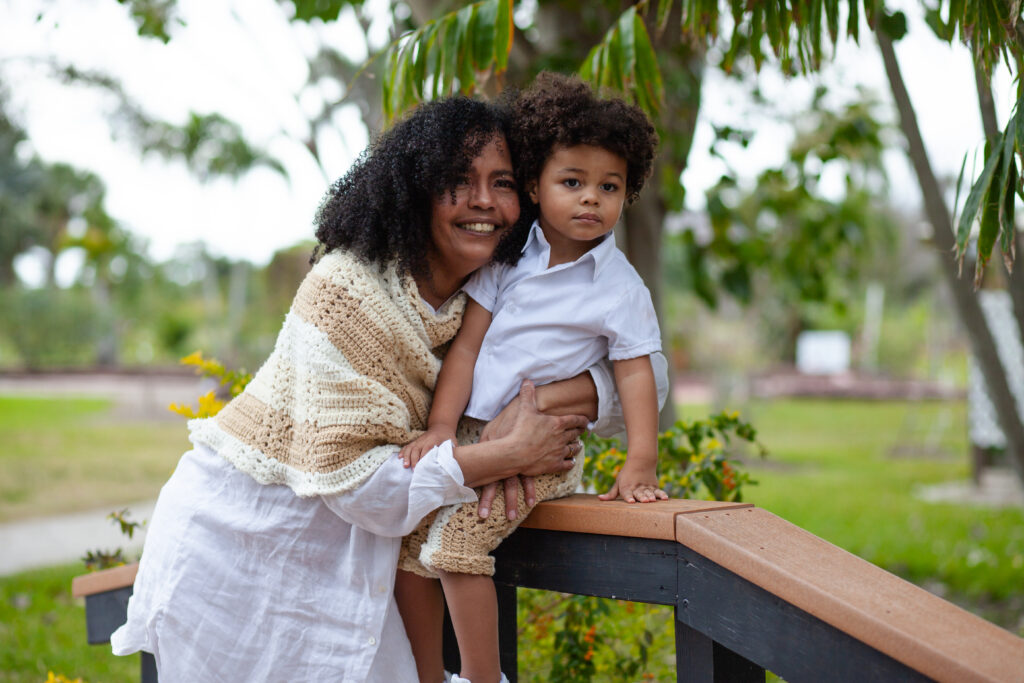 Grandma hugs grandson who is seated on railing