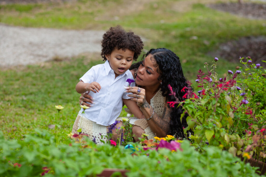 Mom shows her young son a purple flower