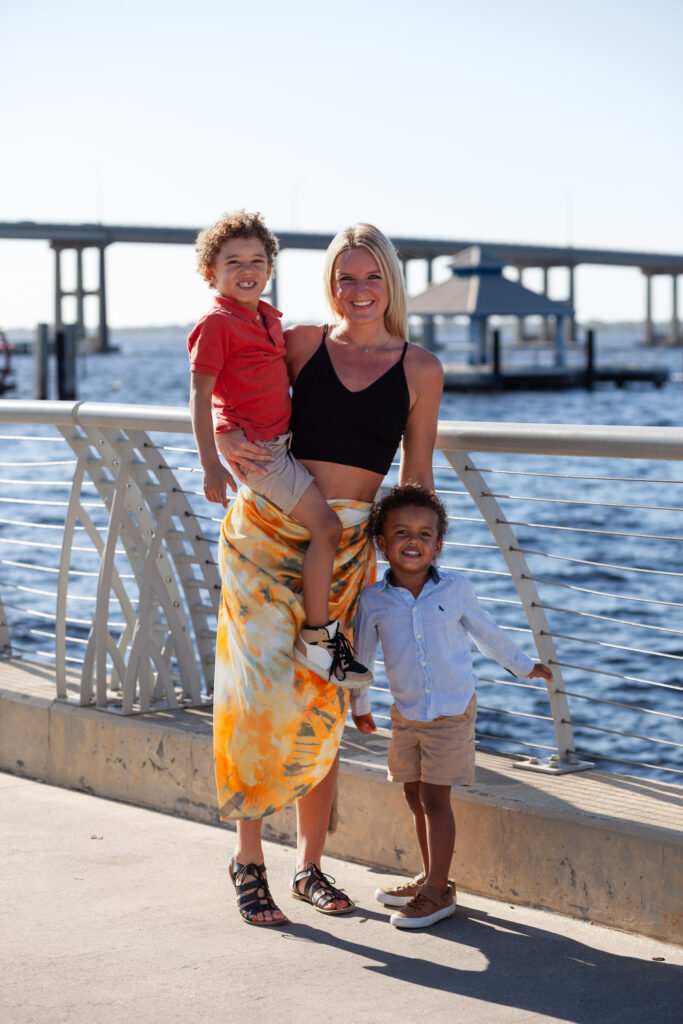 Mom and two sons smiling by a river