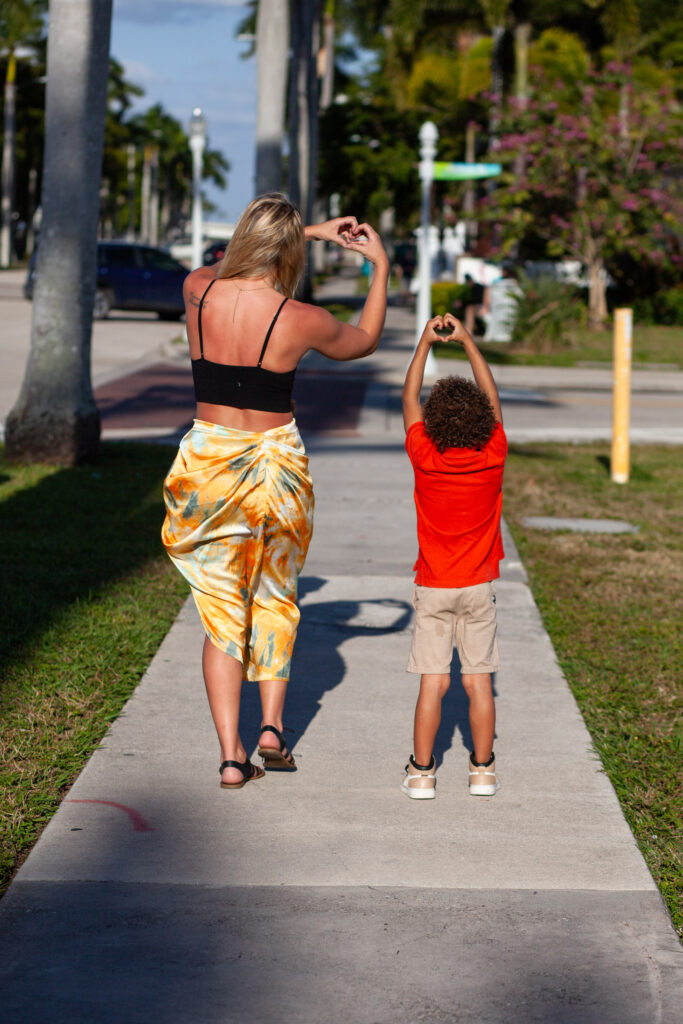 Woman and her son making hearts with their hands