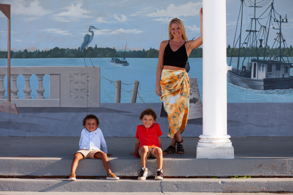 Mom and two sons pose in front of a mural