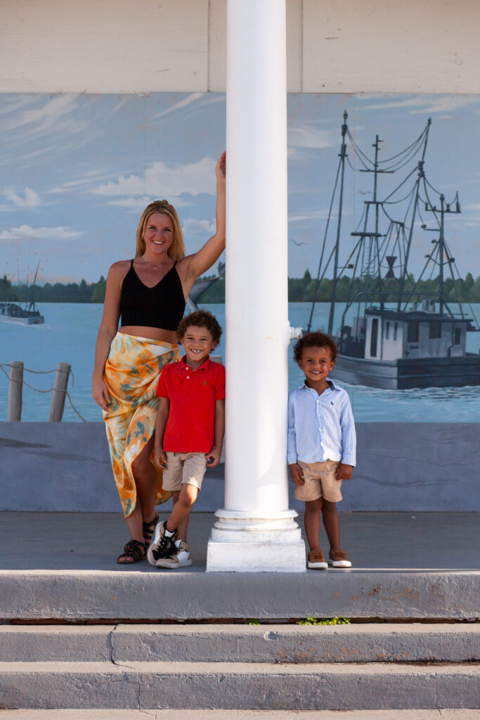 Mom and two sons pose around a column