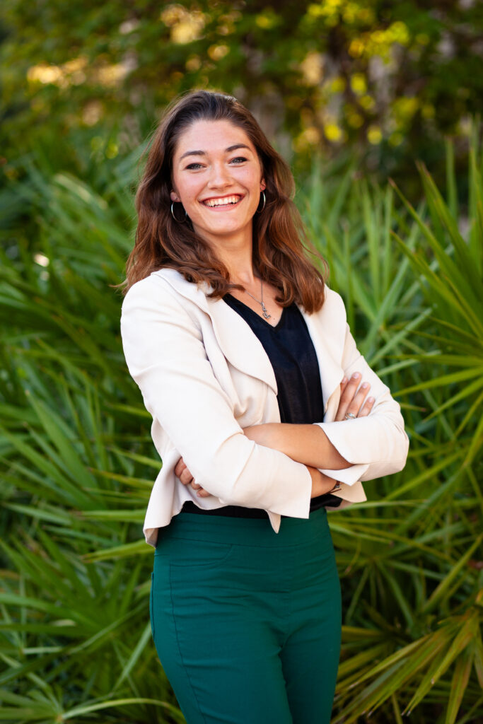 Woman headshot in front of natural green background in Downtown Fort Myers