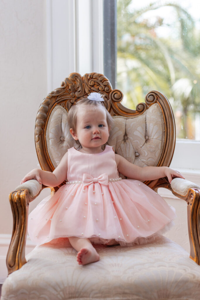 One year old girl sitting on vintage chair