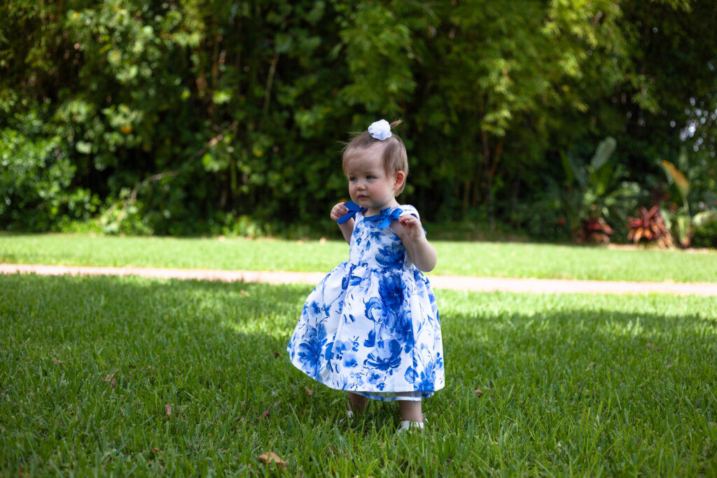 one year old girl in blue dress outside