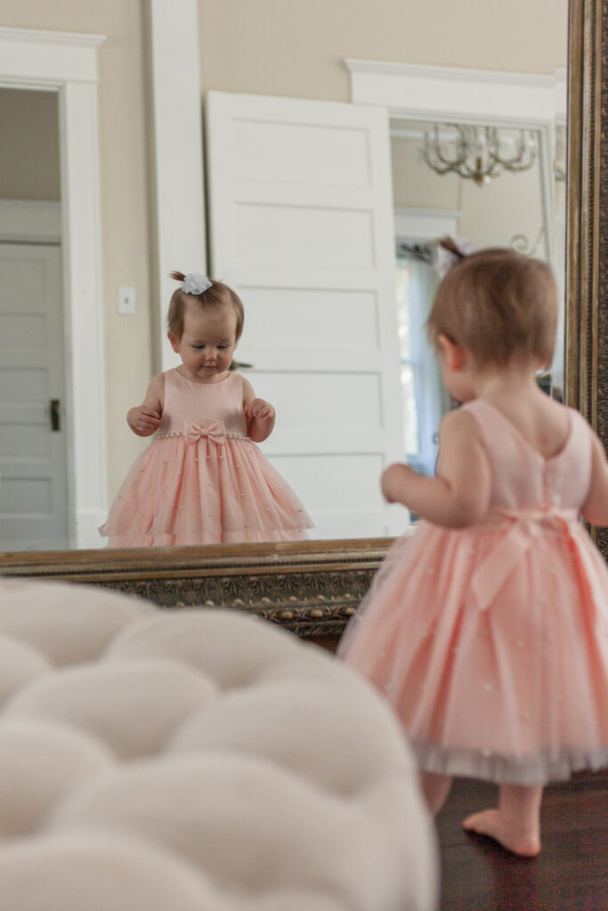 one year old looks at reflection