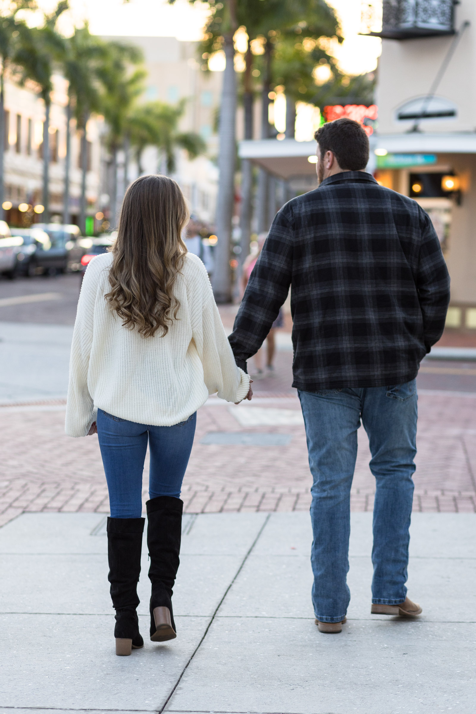 Couple walks away holding hands on Downtown Fort Myers sidewalk