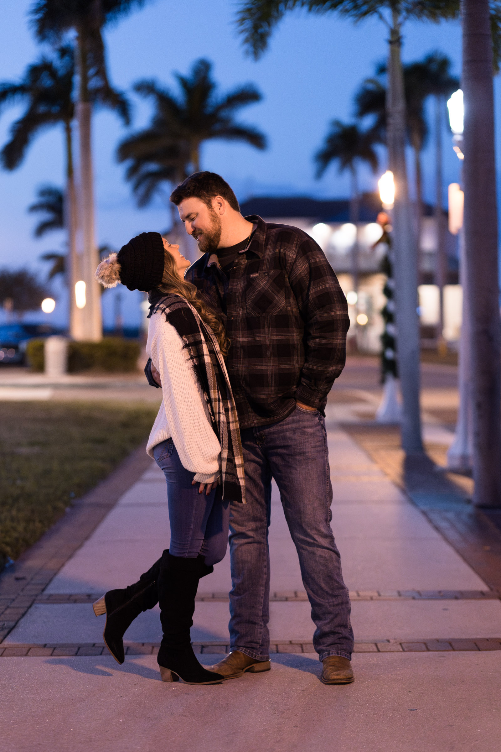 Girl smiles up at her boyfriend with blue hour skies in the background