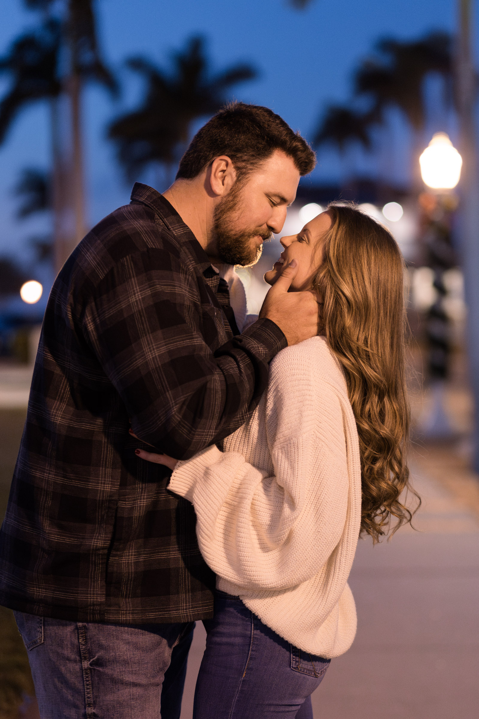 Couple about to kiss with blue hour skies behind them