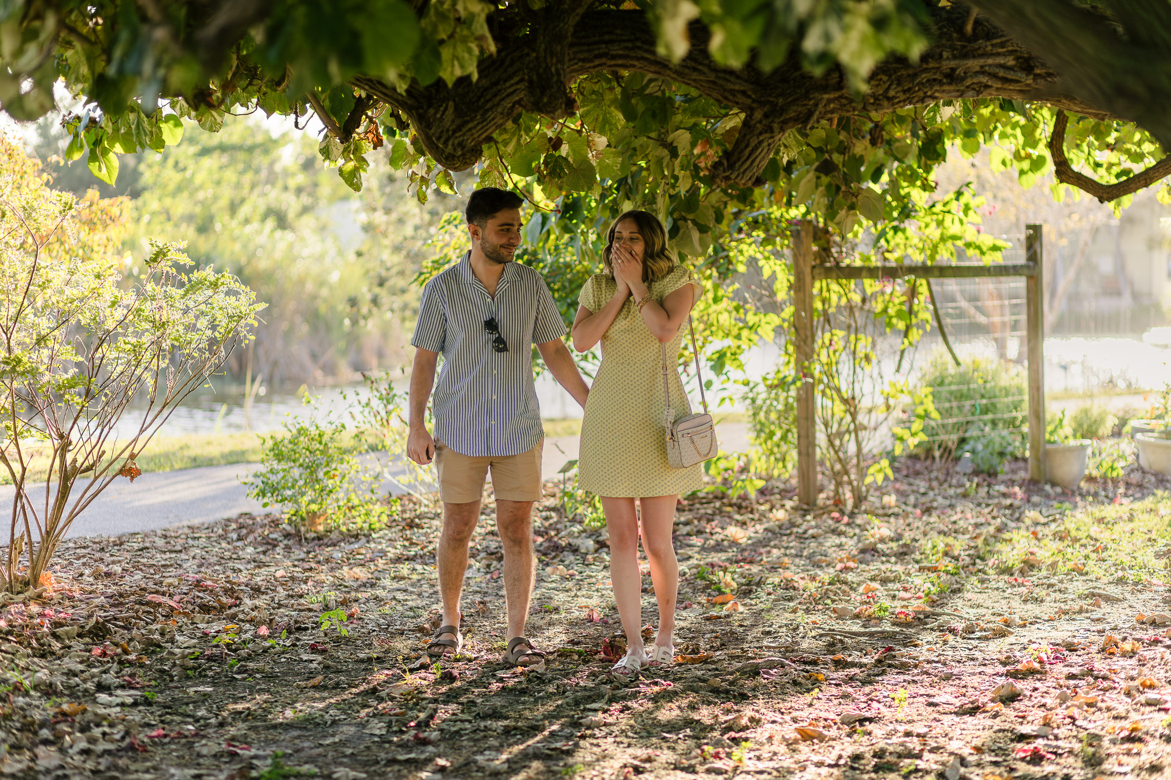Photo of surprised new fiance when she notices the surprise proposal photographer