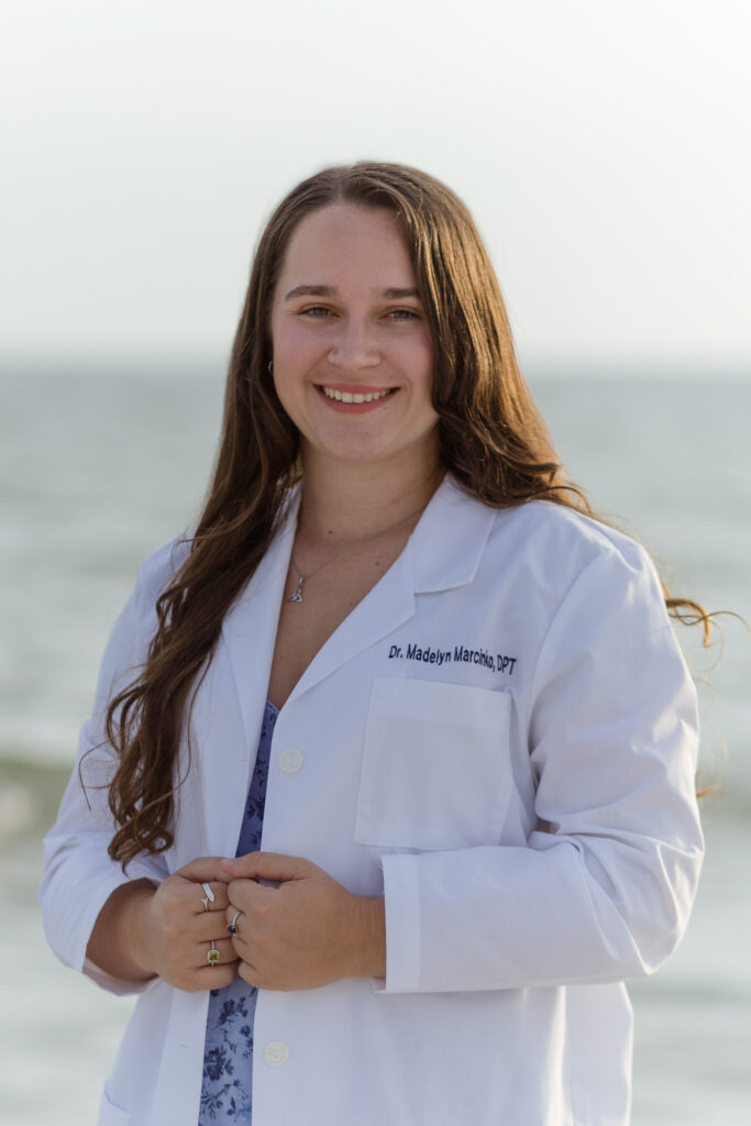 Woman wearing her doctor's white coat for graduation photos