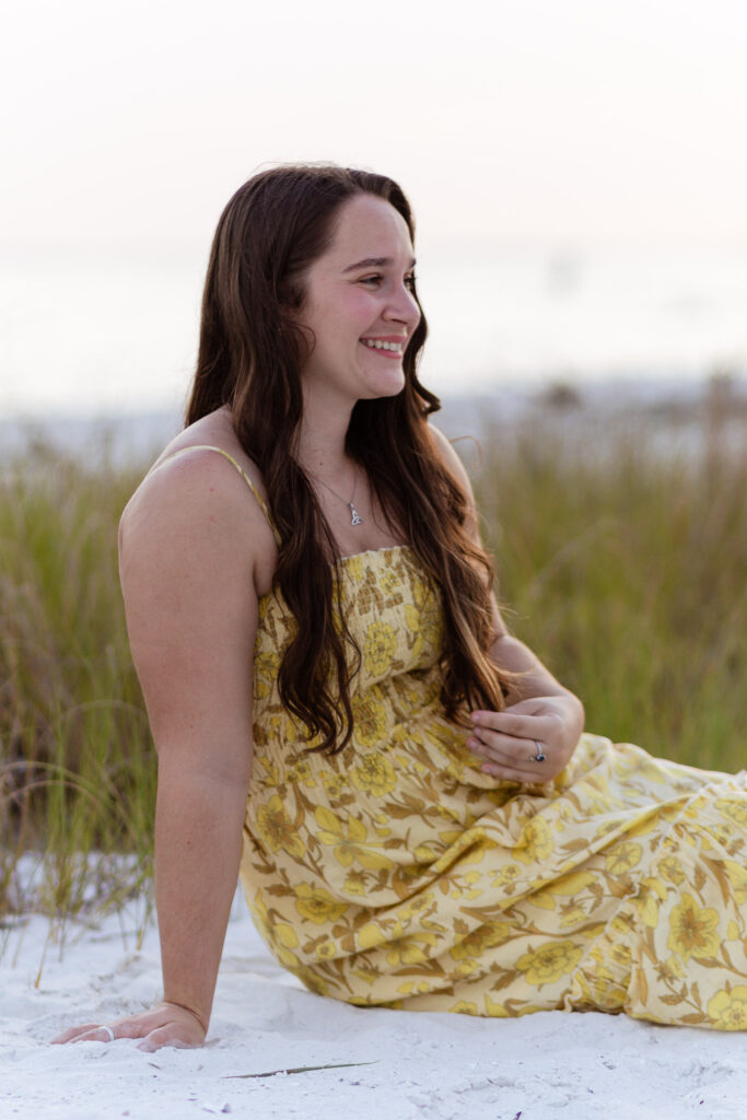 Woman smiling away from camera sitting on the beach