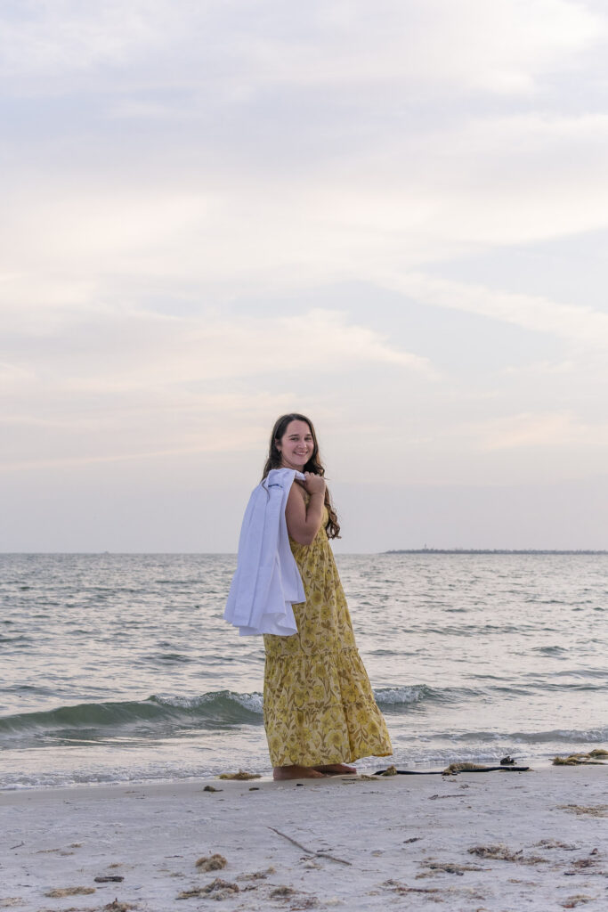 Woman with doctor's white coat draped over her shoulder at the beach