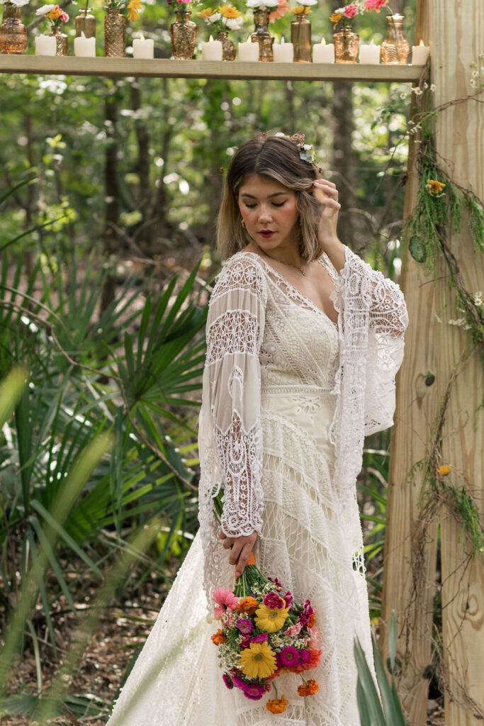 Bride tucks her hair back and looks down at her bouquet