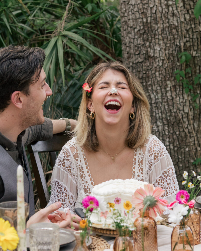 Bride laughs with frosting on her nose at her elopement