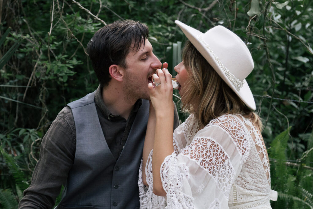Couple bites each side of a smores during their elopement