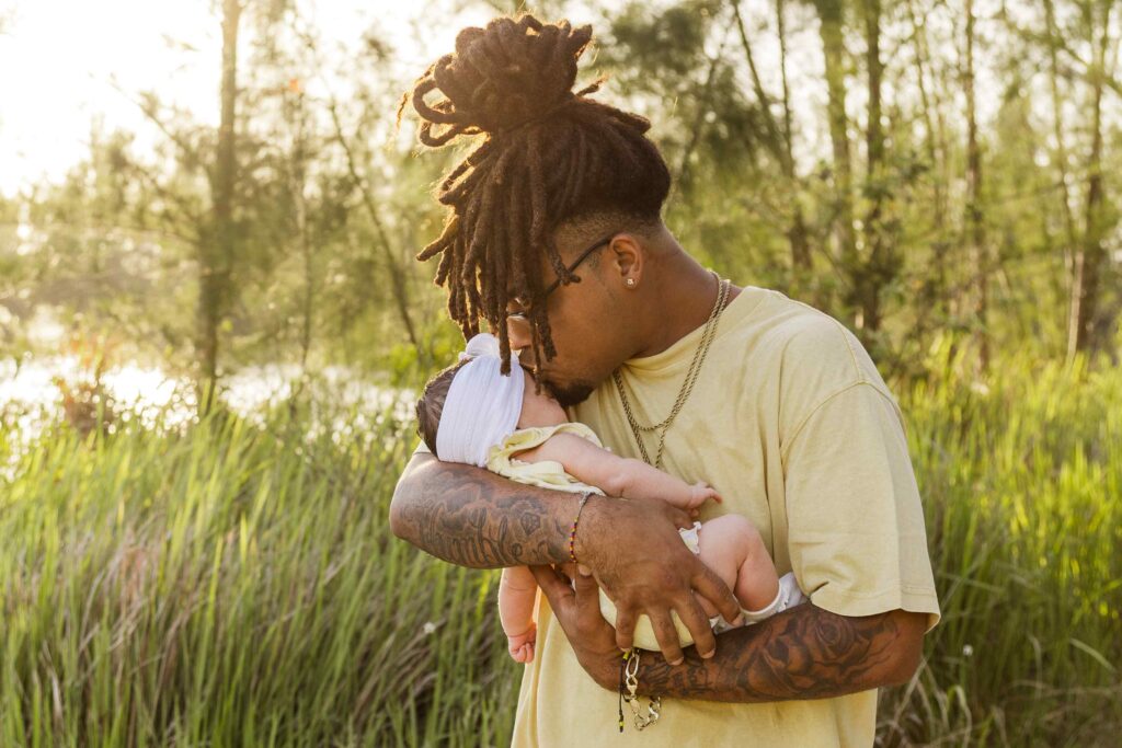 Dad kisses his infant daughter on the forehead
