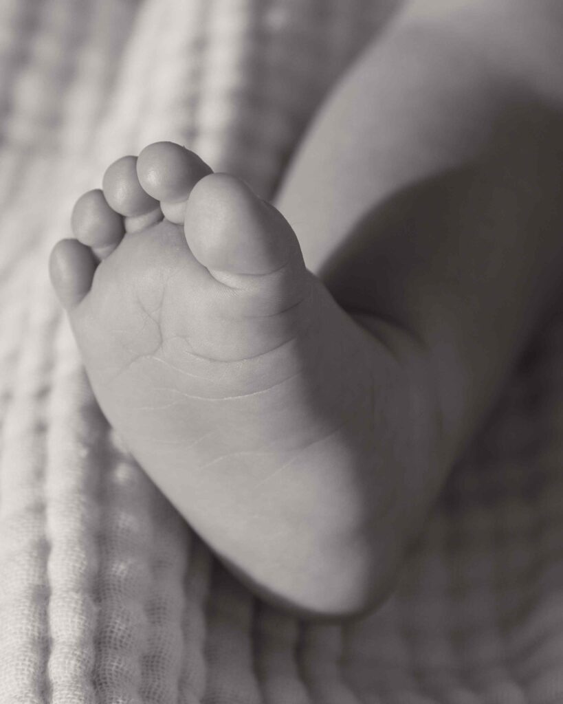 Greyscale closeup of baby girl's foot