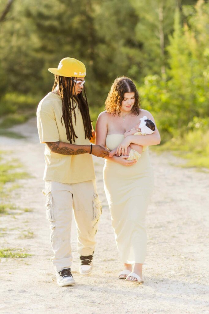 Family of three walking on a tree lined path at a Lehigh Acres park