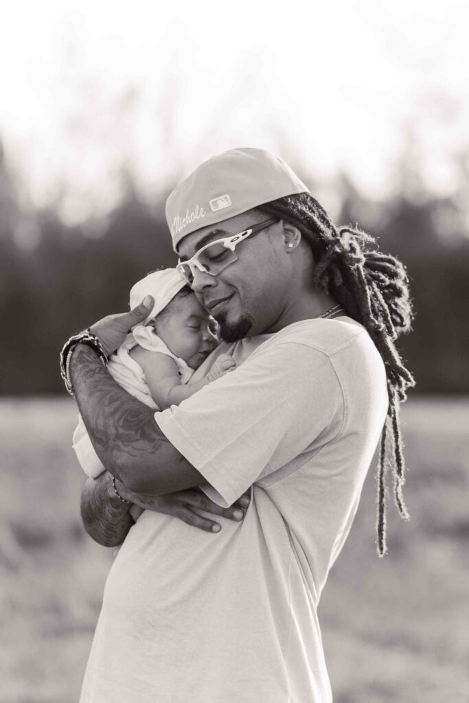 Greyscale image, dad hugs infant daughter