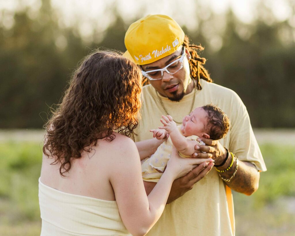 Dad passing infant daughter to mom