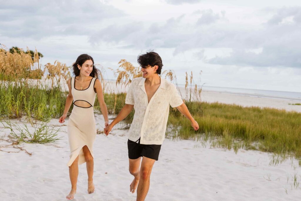 Couple running and laughing on the beach