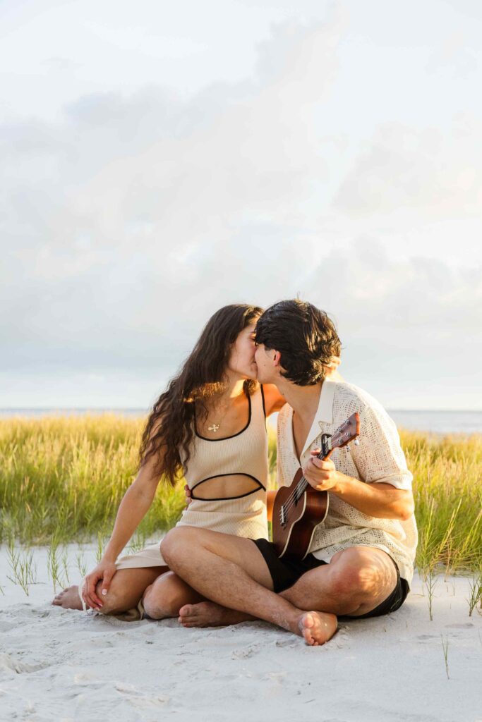 Couple kisses over ukulele on the beach