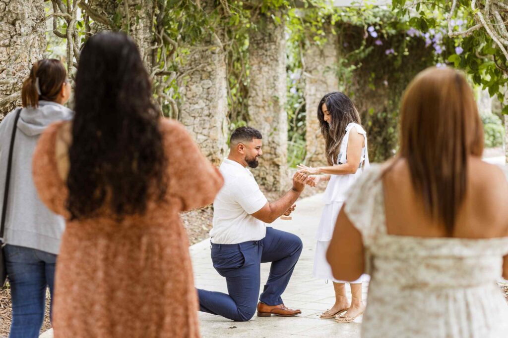 Man places ring on fiancé's finger as family watches