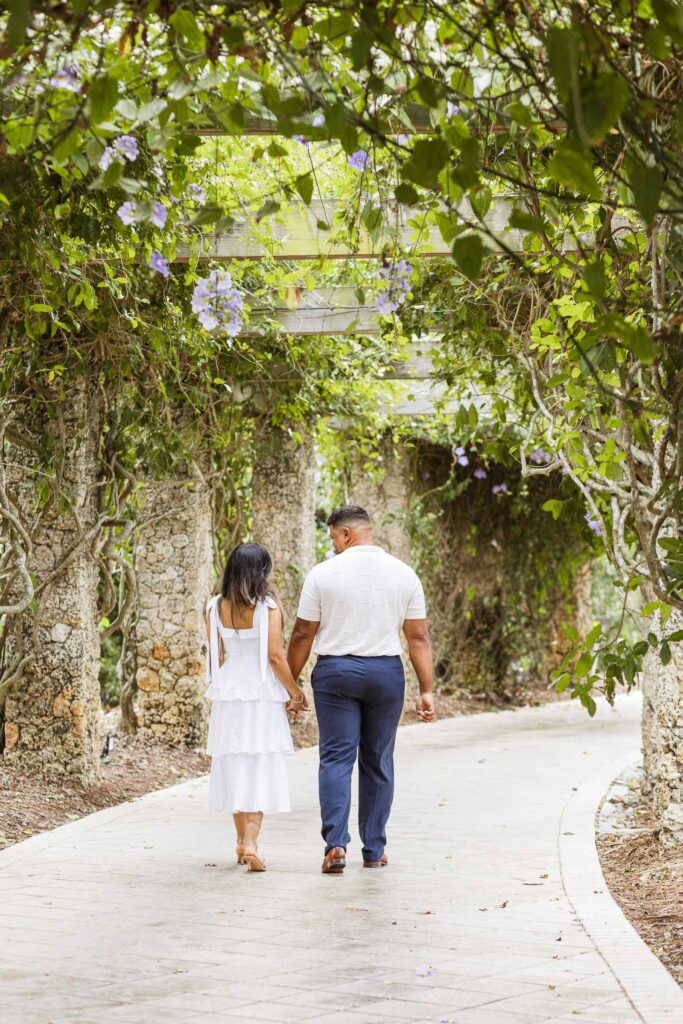 Couple walking through the flower tunnel at the Naples Botanical Garden