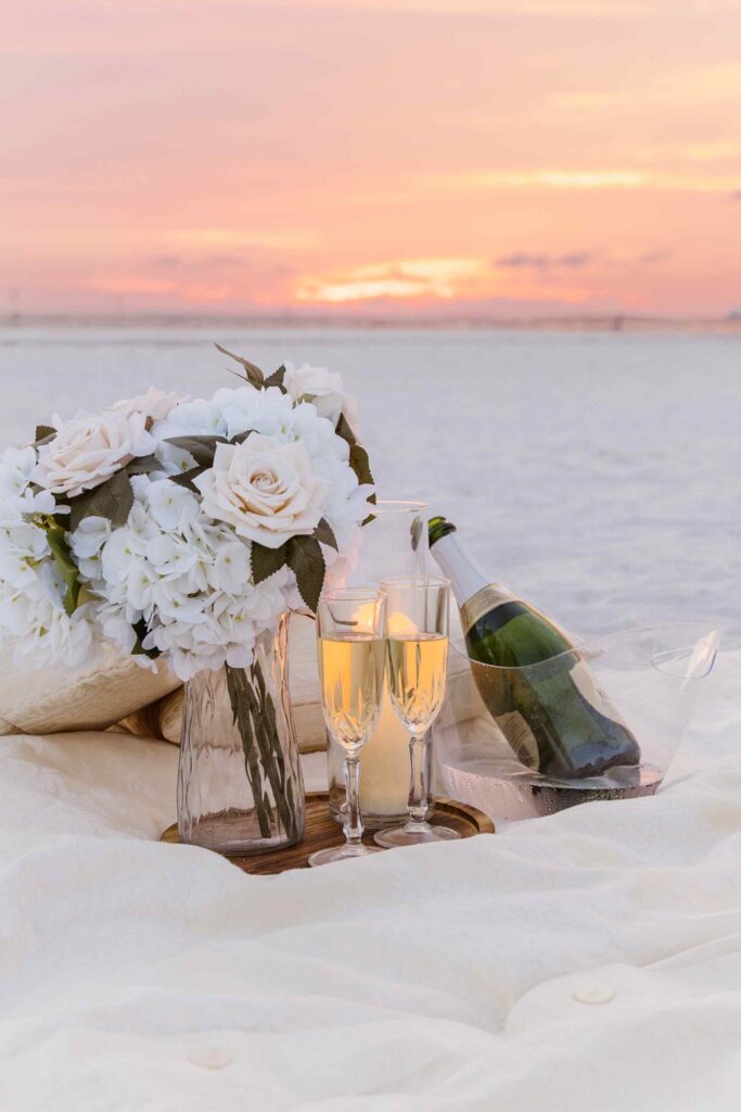 Champagne beach picnic at sunset