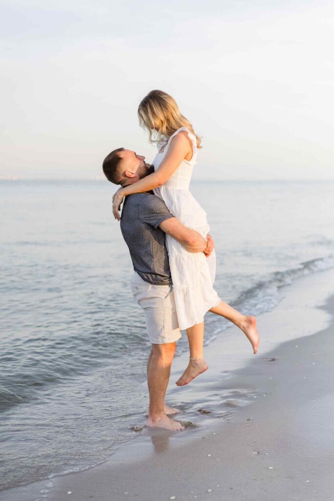 Man lifts up his new fiancée during their engagement session