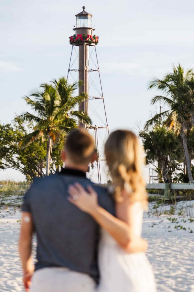 Image of couple's backs as they look towards the Sanibel Lighthouse