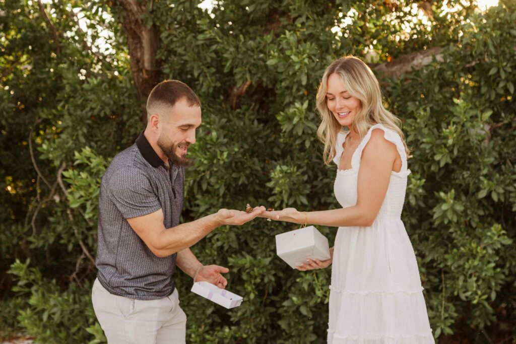 Couple holds two butterflies as they release them after their proposal