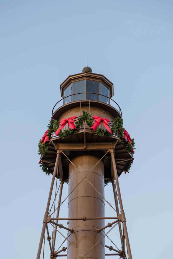 The Sanibel Lighthouse wrapped in a green Christmas garland and red bows