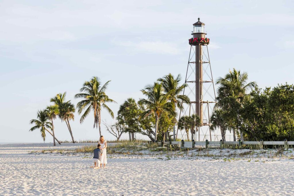Man is proposing to girlfriend to the left of the Sanibel Lighthouse