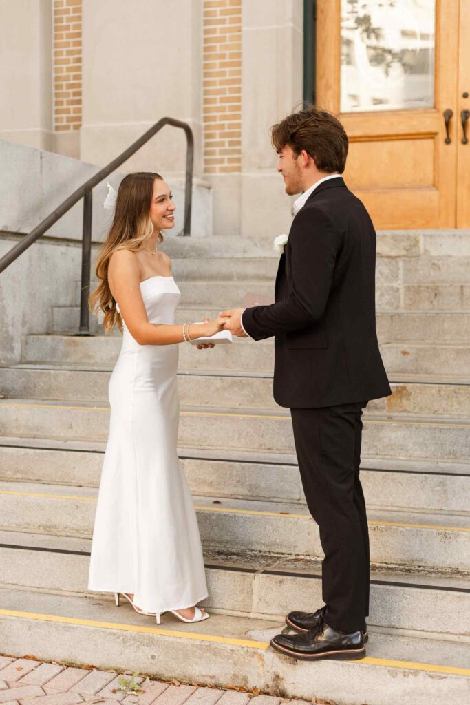 Bride and groom reading vows during wedding on Old Lee County Courthouse steps