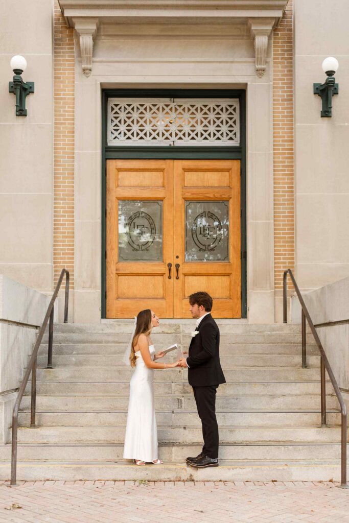 Bride and groom reading vows during wedding on Old Lee County Courthouse steps