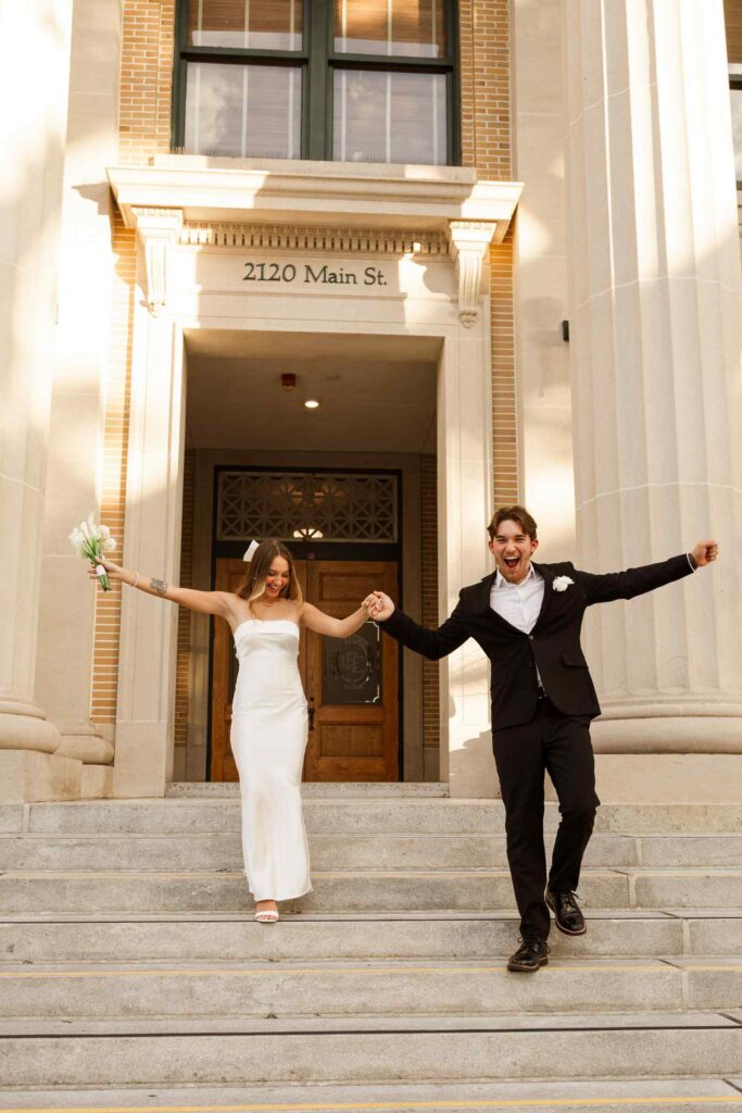 Bride and groom cheerfully descend Fort Myers courthouse steps after their marriage