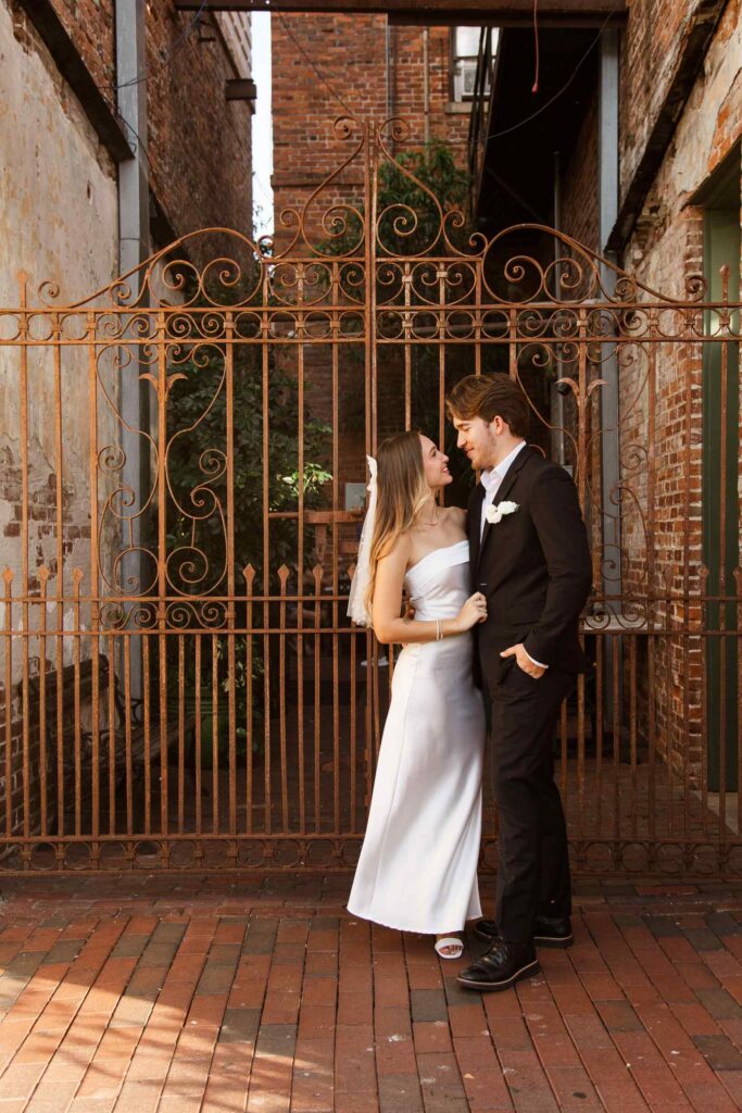 Bride and groom pose for a photo in the Patio de Leon alley