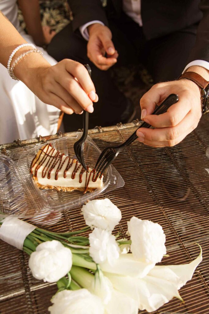 Bride and groom dig into cheesecake together