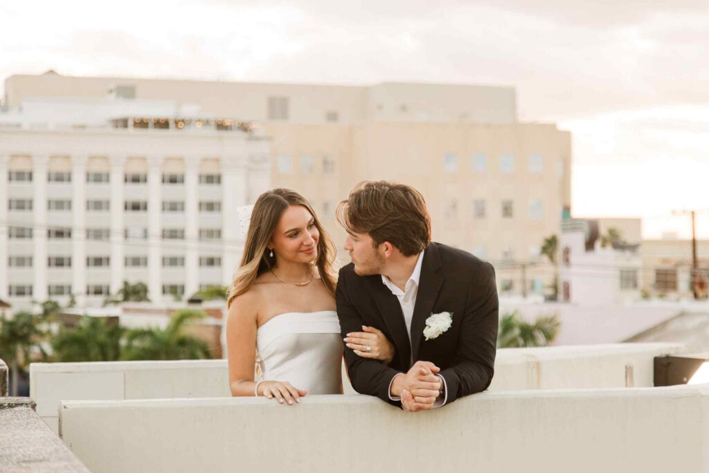 Bride and groom smile at each other on top of a parking garage in Downtown Fort Myers