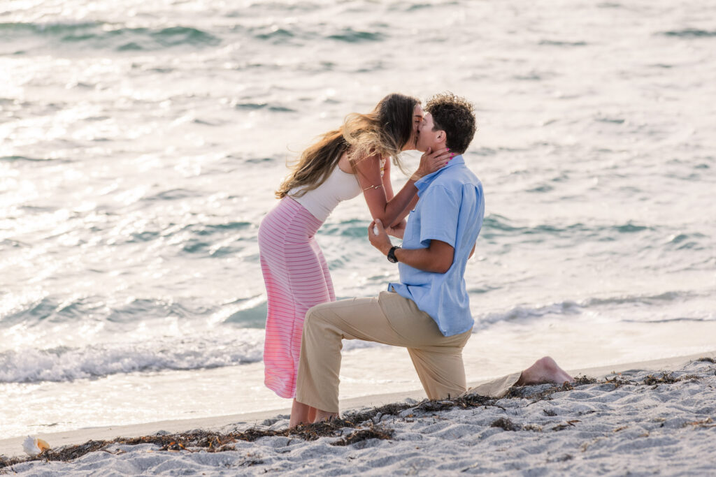 Woman kisses boyfriend on proposal kneel
