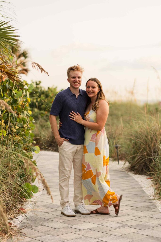 Couple posing on a path in the middle of beach grass