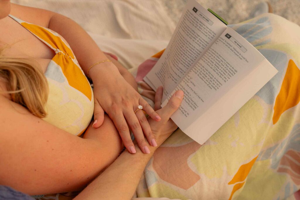 Couple reading together with their hands together on the book