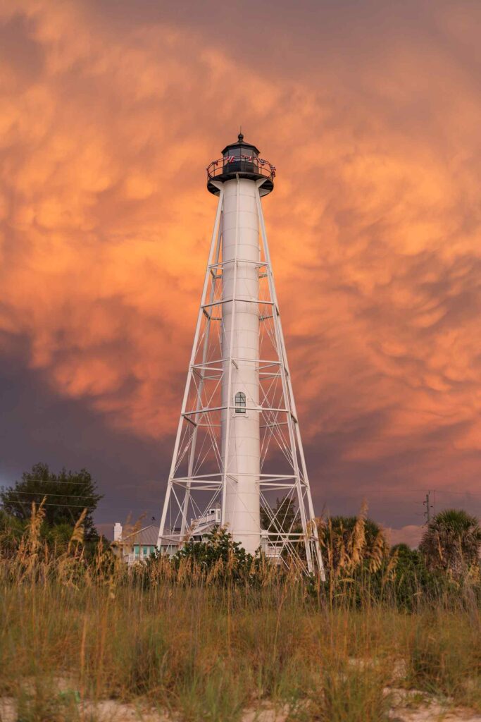 The Gasparilla Island Lighthouse with bright orange clouds behind it