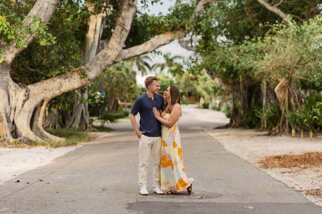 Couple smiling at each other in the middle of Banyan Street on Boca Grande