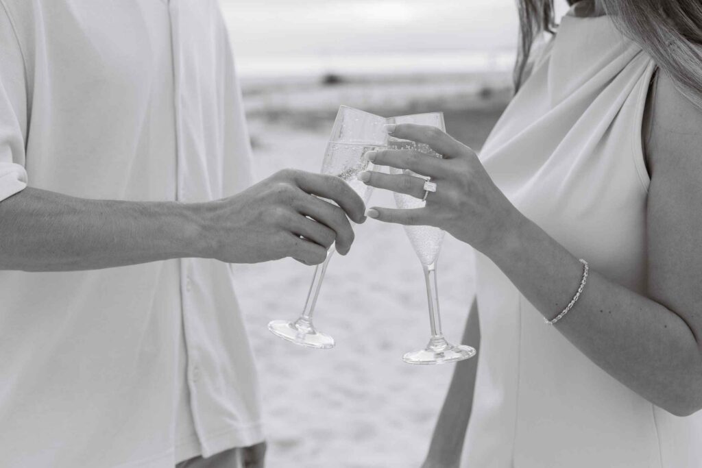Couple toasts champagne glasses, black and white image