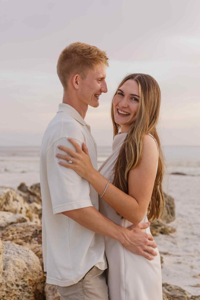 Couple belly to belly, woman is laughing at the camera and man is smiling at her